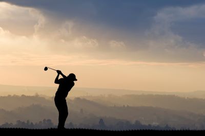 Golfer Silhouetted Against Clouded Sky
